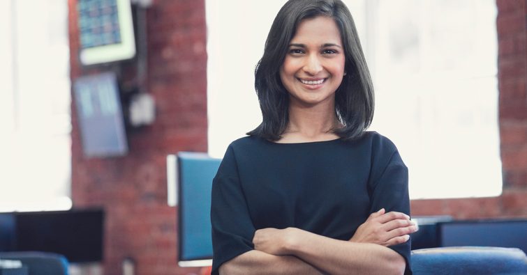 An Indian woman smiling in a classrom